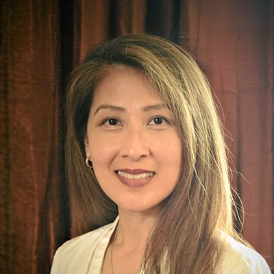 Eye Doctor Sharon Than Smiling In Front Of Curtain